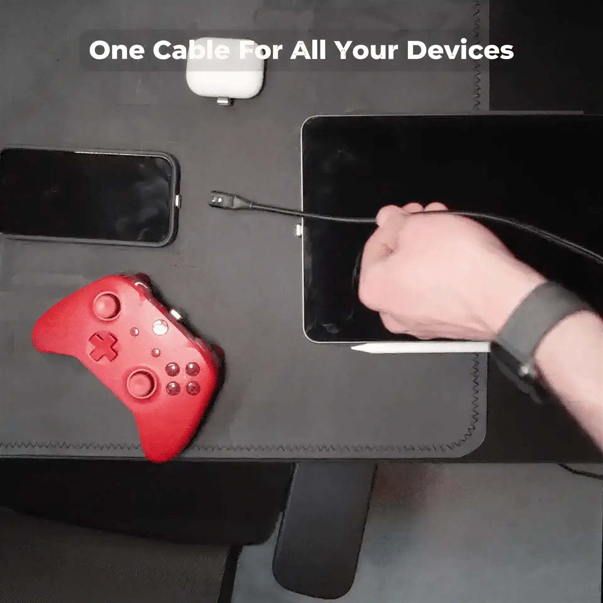 Volta MAX Cable connected to a tablet, with a smartphone, gaming controller, and AirPods nearby.